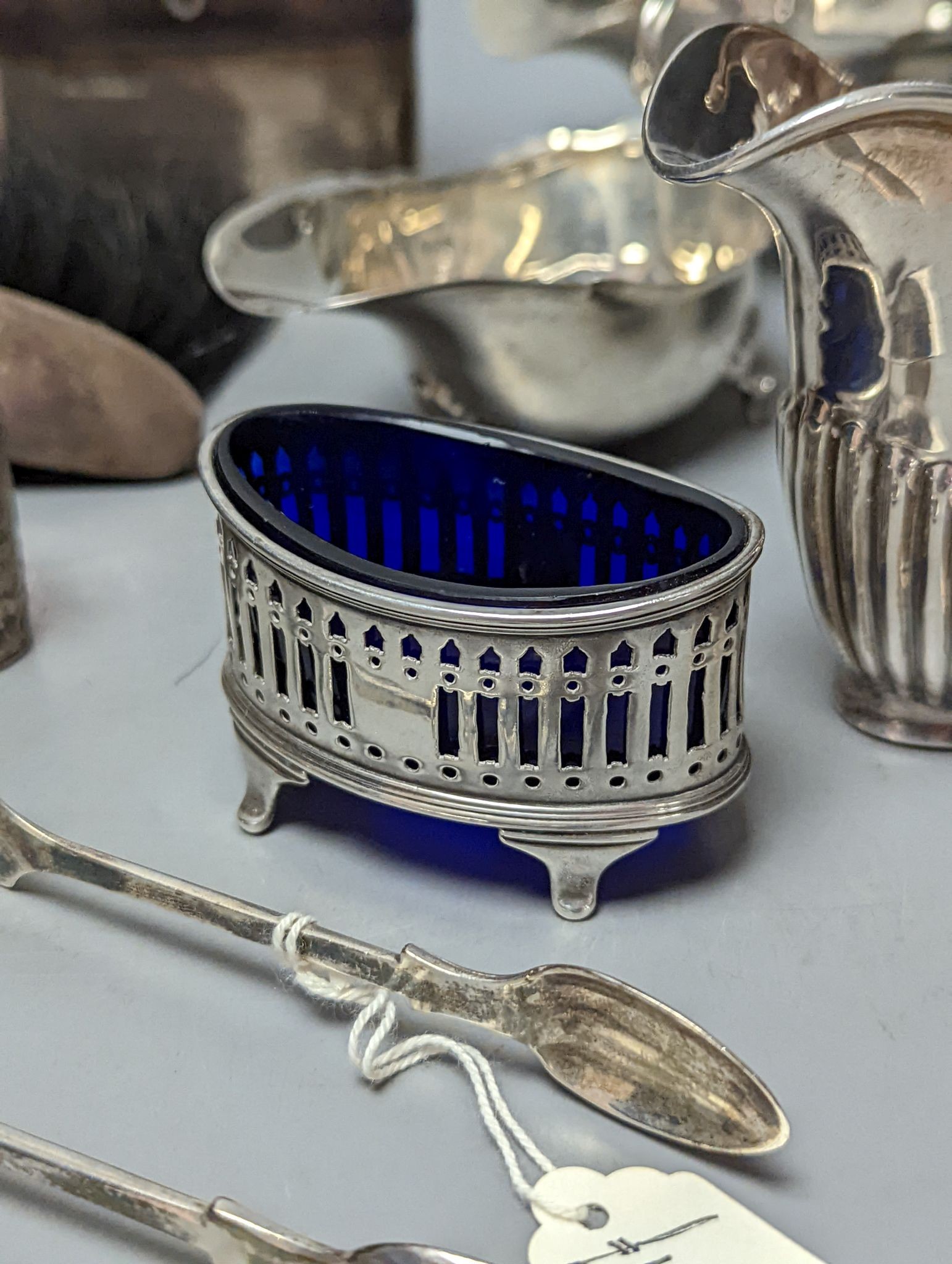 A group of assorted silver items including George V silver mounted hip flask(bruise), a pair of silver sauceboats(a.f.) one other sauceboat, sterling box, two silver cream jugs, cigarette box, salt, sugar tongs, brush an